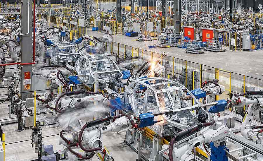 An automotive manufacturing assembly line showcasing robotic arms assembling car frames, highlighting the role of zinc in die-casting for automotive parts.