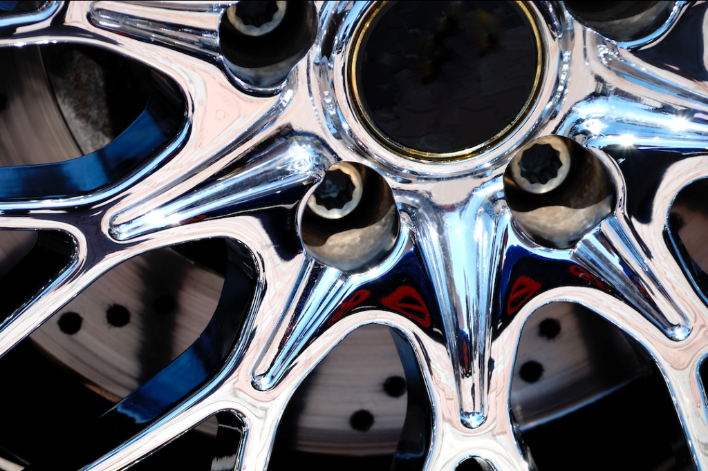 Close-up of a chrome-plated automotive wheel rim showcasing the reflective surface created through chromium electroplating