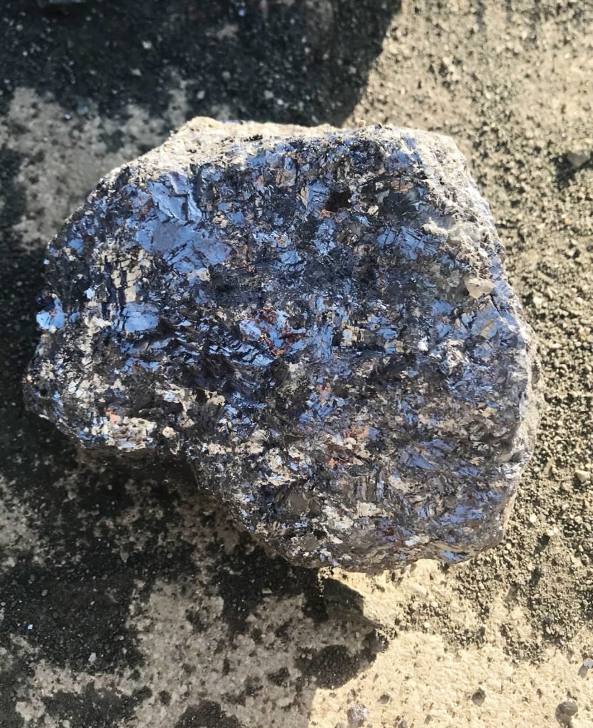close-up image of a lead-zinc ore from Bare Syndicate, showcasing its metallic luster and reflective surfaces, indicating the presence of lead (galena) and zinc minerals.