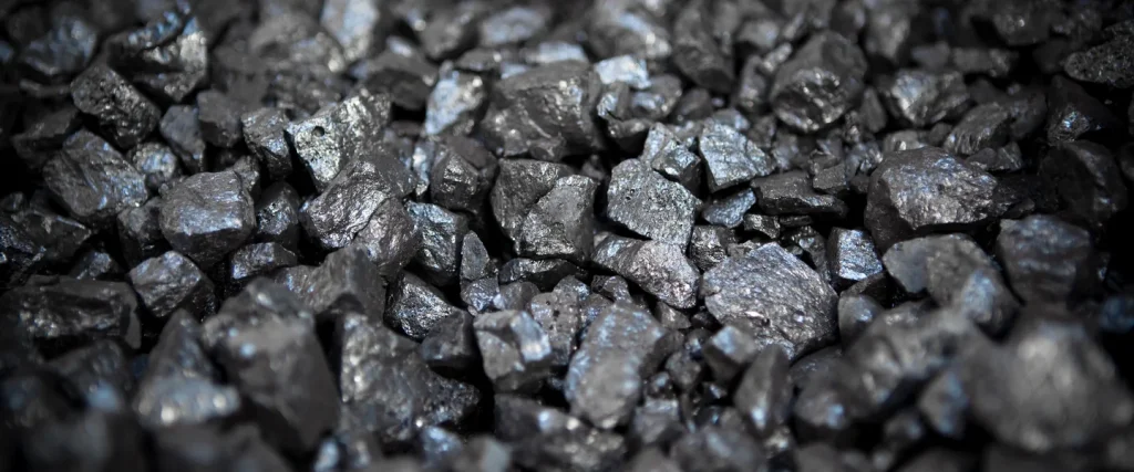 Close-up view of raw black metal ore rocks, showcasing their rough texture and shiny surfaces.