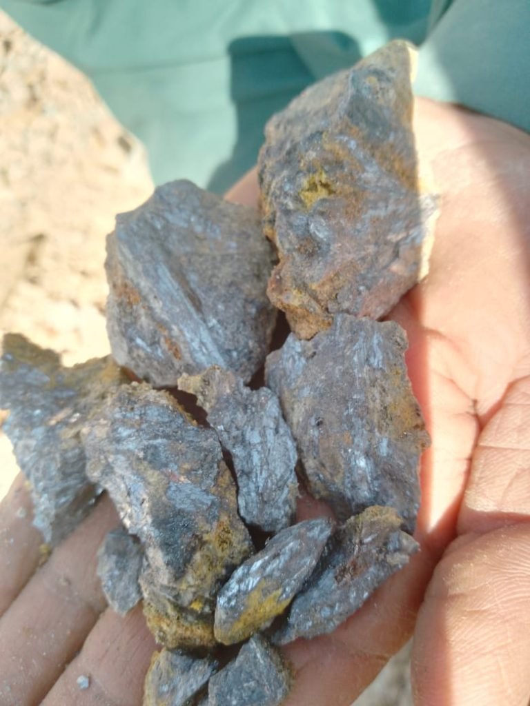 A close-up of freshly mined copper ore held in hand, showcasing its raw metallic texture and mineral composition. As copper prices fluctuate due to global demand and supply chain challenges, Bare Syndicate ensures high-quality, ethically sourced copper for industrial applications.
